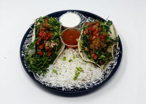 Plated meal with rice, greens, and a tortilla with toppings on a decorative plate.