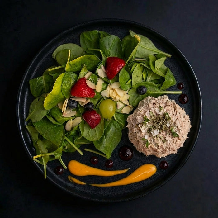 Plated salad with a round dish of food on a dark background