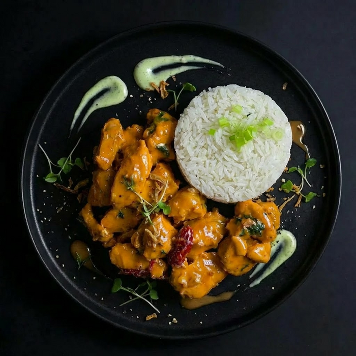 Plated dish with orange chicken and white rice on a dark background