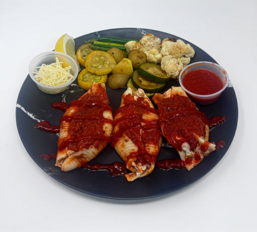 Plated dish with grilled items, vegetables, and side dishes on a white background