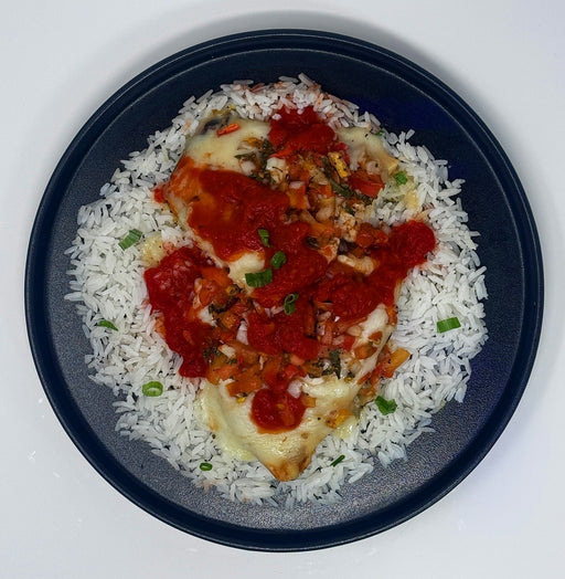 Plated dish of chicken with tomato sauce over white rice on a dark plate.