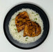Grilled chicken with pineapple on a bed of rice on a black plate.