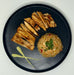 Black plate with grilled bread slices and a ball of fried rice on a white background