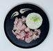 Black plate with fried chicken and white rice on a light gray background