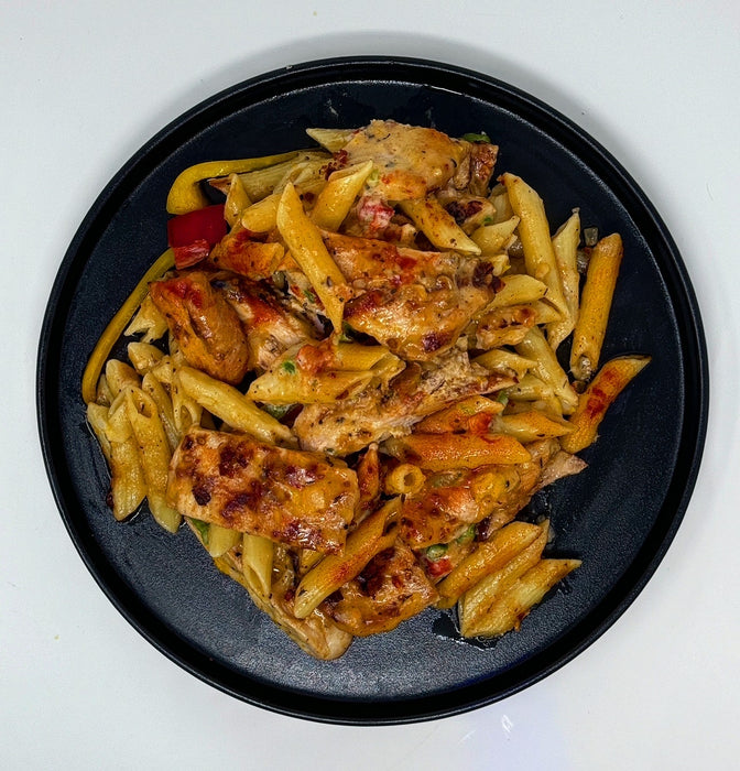 Pasta dish with chicken on a black plate
