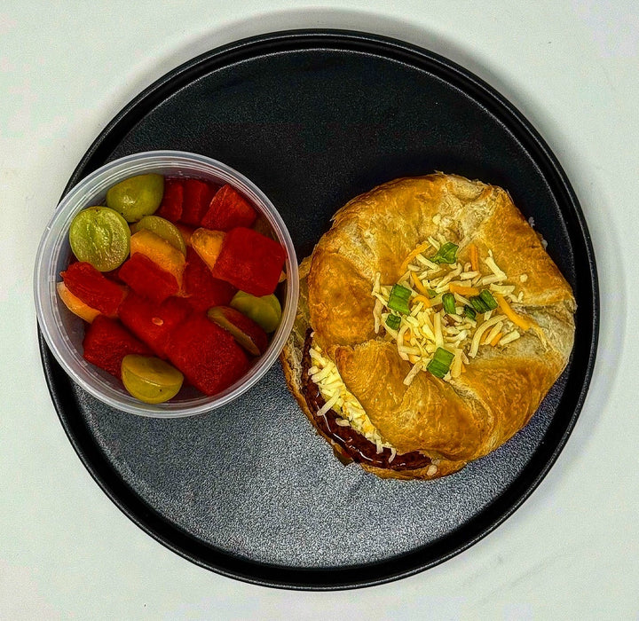 Sandwich and container of gummy bears on a black plate